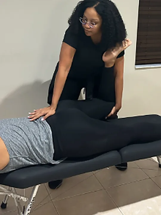 Dr. Serena Brown performing a chiropractic adjustment on a portable table in a client's home